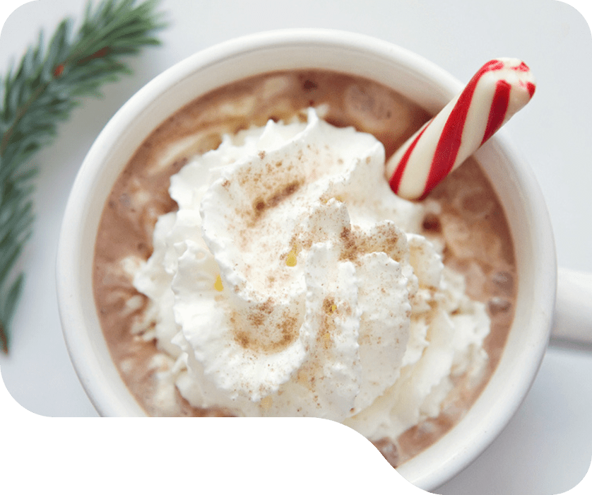 Peppermint Protein Hot Chocolate topped with whipped cream and candy cane
