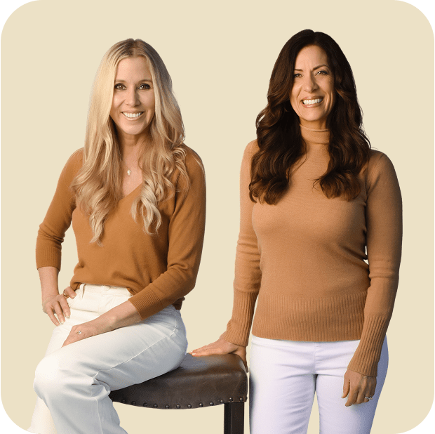 Two women smiling in sweaters.